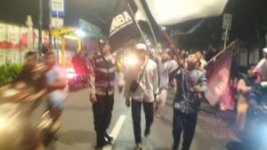 Anggota Bhabinkamtibmas dan Kapolsubsektor Kayu Awet Melaksanakan Pengamanan Pawai Obor Shalawat Dalam Rangka Menyambut Tahun Baru Islam 1446 H.