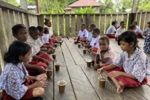 Satgas Yonif 503 Kostrad Bagikan Bubur Kacang Hijau Bagi Anak – Anak