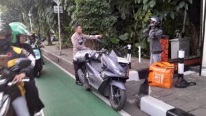 Aiptu Setiawan Membantu Pengendara Barang Paket Yang Terjatuh
