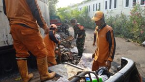 Babinsa Kelurahan Pulogebang Bersihkan Sampah Yang Menumpuk