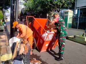 Serda Heriansah, Babinsa Kelurahan Pisangan Timur Membantu Warga Melaksanakan Pembersihan Sampah.