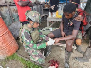 Satgas Yonif 323 Kostrad Memberikan Pertolongan Pertama Masyarakat Yang terluka