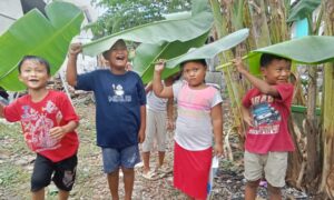 Anak -anak Pemalang Manfaatkan Daun Pisang Buat Payung Saat Hujan Tiba