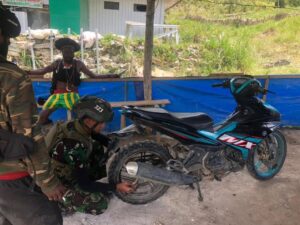 Prajurit Satgas Yonif 323 Kostrad Perbaiki Kendaraan Warga