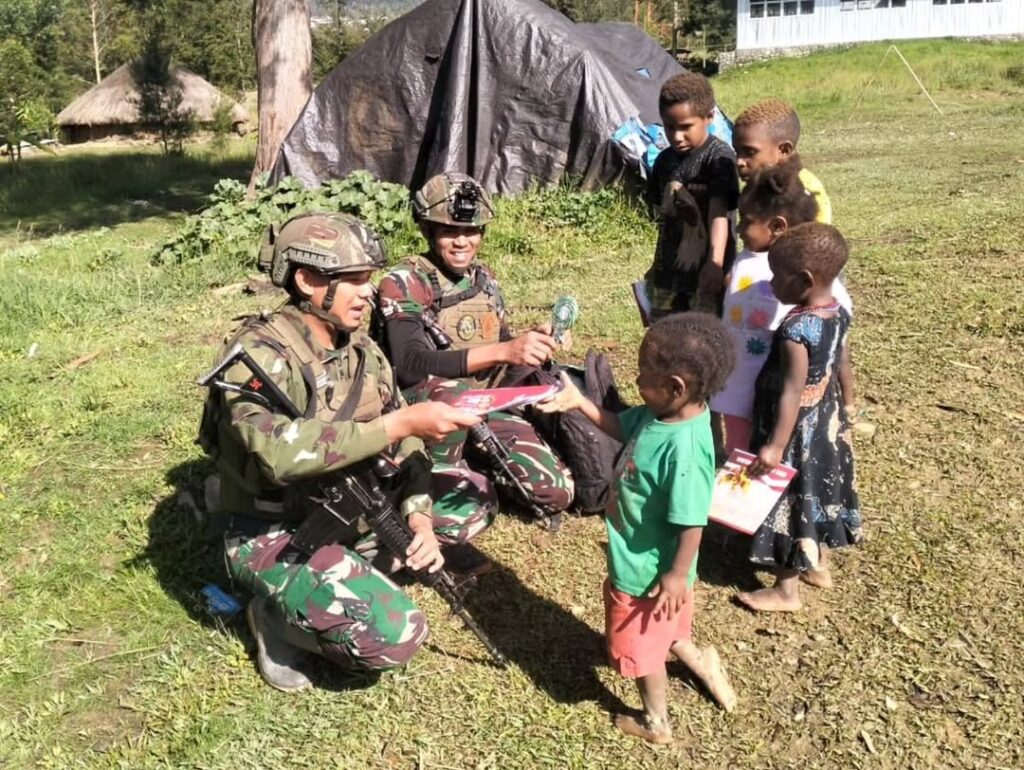 Satgas Yonif 323 Kostrad Bagi-Bagi Buku Tulis Untuk Anak-Anak Kampung Kago