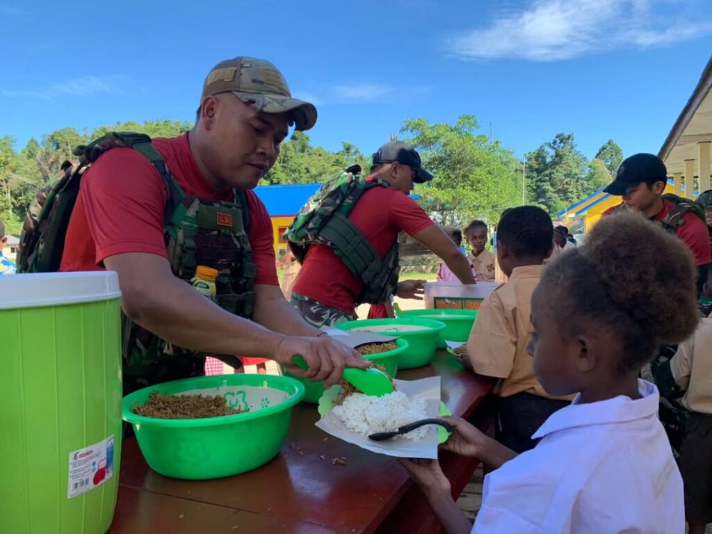 Satgas Yonif 501 Kostrad Bagikan Makan Siang Gratis, Anak-Anak SD di Maybrat Ceria