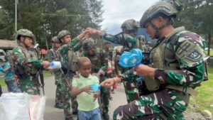Satgas Yonif 323 Kostrad Bagikan Makanan dan Permen untuk Anak-Anak Kampung Kago, Ciptakan Senyum dan Kebersamaan